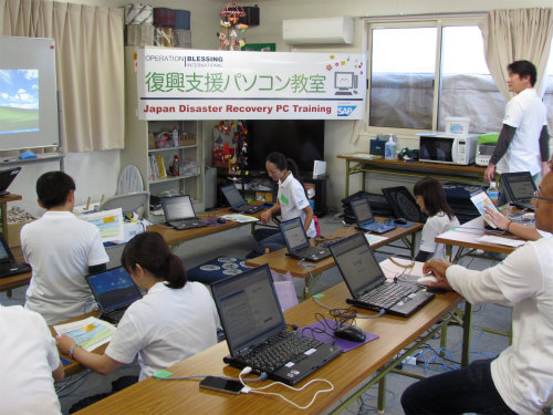 手早くセッティングを行うSAP Japan TEARS team(SAPジャパン株式社の震災復興支援チーム）の皆さん。 今回の教室で使用しているノートパソコン20台は、Japan TEARSから寄贈されたものです。　 